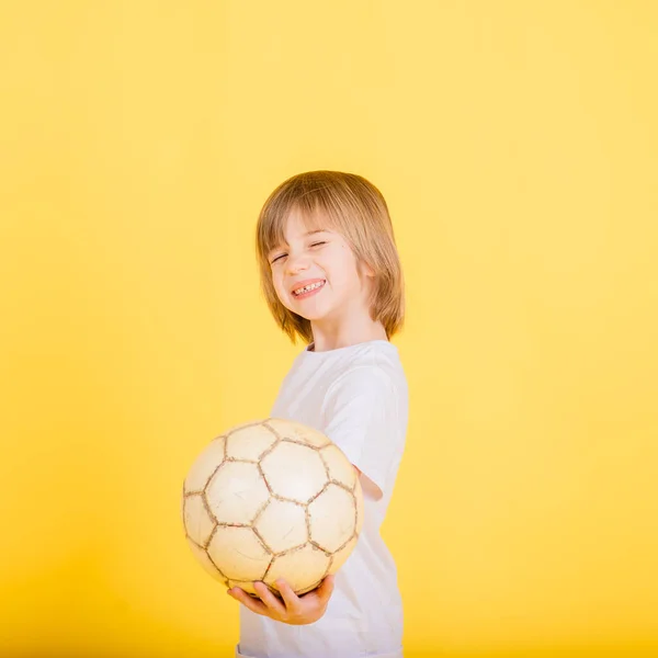 Portret Chłopca Trzymającego Piłkę Nożną Studio Żółte Tło — Zdjęcie stockowe