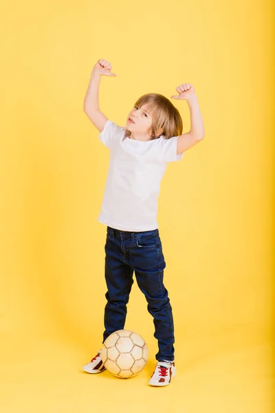 Retrato Menino Segurando Bola Futebol Estúdio Fundo Amarelo — Fotografia de Stock