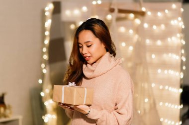 Noel arifesinde mum yakan düşünceli, güzel Asyalı bir kadın dilek tutuyor.