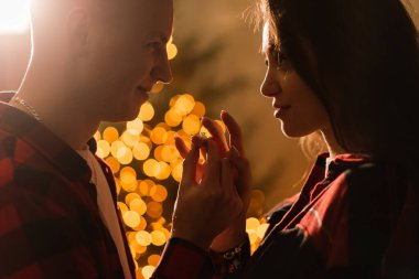 Aşk, Noel, çift, evlenme teklifi. Mutlu adam evdeki kadına elmas nişan yüzüğü veriyor.