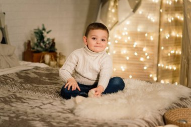 Noel kıyafetleri içinde, Noel zamanı fotoğraf stüdyosu çekimlerinde, küçük tatlı bir çocuğun Noel portresi.