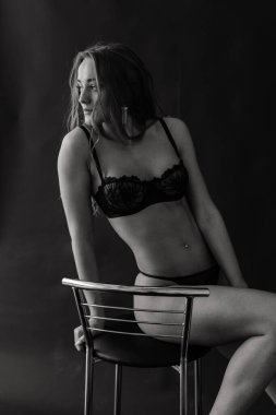 Baştan çıkarıcı siyah iç çamaşırlı, çoraplı, stüdyo fotoğraflı mükemmel genç bir kadın.