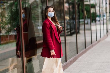 Restoranda yüz maskesi takan genç bir kadın, koronavirüs salgınını korumak için yeni normal bir konsept.