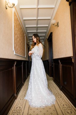 Beyaz elbiseli, klasik tarzda, doğal, masum ve gülümseyen Asyalı bir kadın.