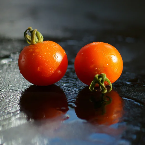 Two tomatoes sprinkled with water — Stock Photo, Image