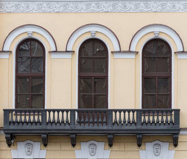 Şehirde eski tarz pencereler, sıva ve dekoratif elementlerle