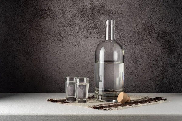 Glass Bottle Glasses Strong Drink White Countertop Gray Wall 免版税图库照片