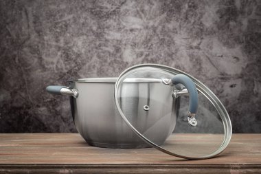 Food pan, stainless steel, on a wooden countertop, against a stuccoed wall