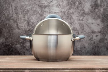 Food pan, stainless steel, on a wooden countertop, against a stuccoed wall