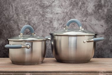 Food pan, stainless steel, on a wooden countertop, against a stuccoed wall
