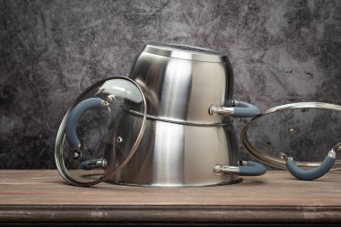 Food pan, stainless steel, on a wooden countertop, against a stuccoed wall