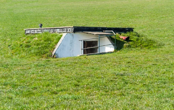 Открытый пейзаж, показывающий бункер в заросшей травянистой атмосфере — стоковое фото