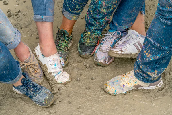 Buty Zauważone Kolorowymi Rozpryskami Farby Błotnistej Ziemi — Zdjęcie stockowe