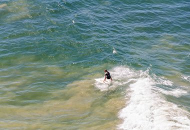 Addis 'in popüler sörf sahili Anglesea, Victoria, Avustralya' da sörf yapan sörfçü