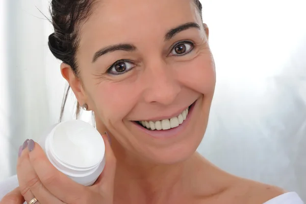 Happy middle aged woman with jar of face cream — Stock Photo, Image