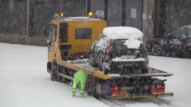28 / 12 / 2020 Cornedo Vicentino, Veneto - İtalya: Sert kar yığını kamyon operatörü, kar zincirlerinin aracının lastiklerine sıkıca bağlandığından emin olur ve yoğun bir kar yağışı sırasında ayrılır.