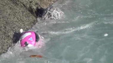 Kirlenmiş nehir çöpleri ve plastik toplar yavaş çekimde zıplıyor.