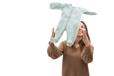 Kollarını açmış genç bir kadın bebek kıyafetlerini havaya fırlatıyor.