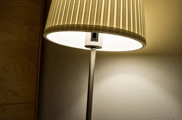 Hotel room lampshade projecting light and shadows on the wall