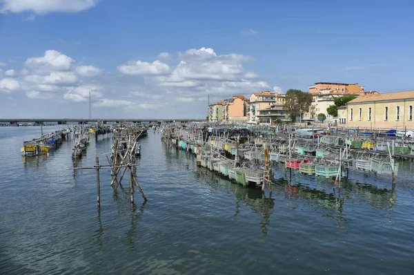 Fishing traps and anchored fishing boats in port. Chioggia seen from from Granatieri di Sardegna street. Laguna Veneta. Italy