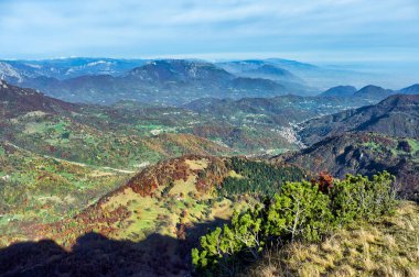 Sonbaharda dağ manzarası, bir tepenin tepesinden uzak vadiye manzara. Ormanlık tepeli doğal manzara.