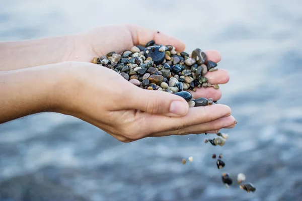 Uma menina brinca com pedras do mar — Fotografia de Stock