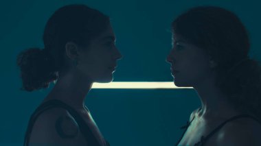 Mavi duvardaki parlak ışıklı kız portresi. Bir kızın neon portresi..