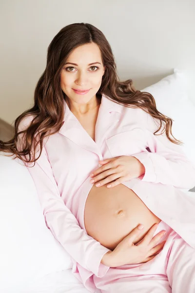 Szép terhes nő az ágyban fekve — Stock Fotó