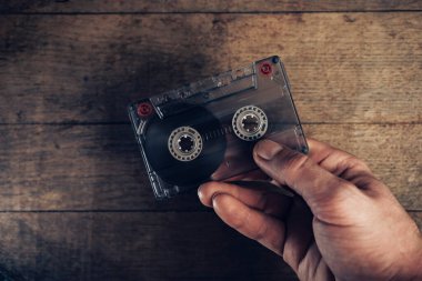 Kahverengi eski ahşap masada el ele tutuşma kaseti. Minimalizm retro tarzı konsept. Tasarım için arkaplan deseni. 