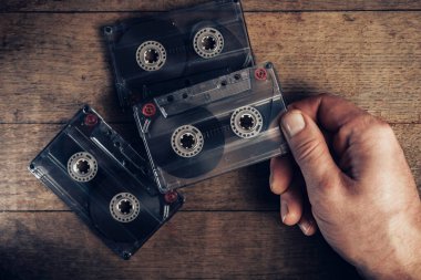 Kahverengi eski ahşap masada el ele tutuşma kaseti. Minimalizm retro tarzı konsept. Tasarım için arkaplan deseni. 