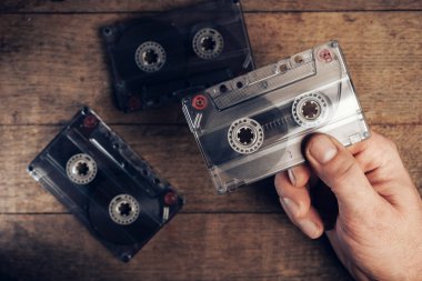 Kahverengi eski ahşap masada el ele tutuşma kaseti. Minimalizm retro tarzı konsept. Tasarım için arkaplan deseni. 