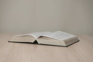 Tahta bir masada kutsal kitabı aç. Güzel beyaz duvar arkaplanı.