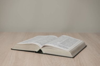 Tahta bir masada kutsal kitabı aç. Güzel beyaz duvar arkaplanı.