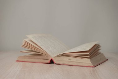 Eski, açık kitaplar. Tasarım için model arka planı. Ahşap masa ve beyaz duvar arkaplanındaki kitap..