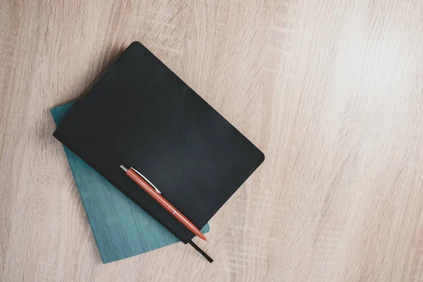 Daily planner on and red pen a wooden table background texture .