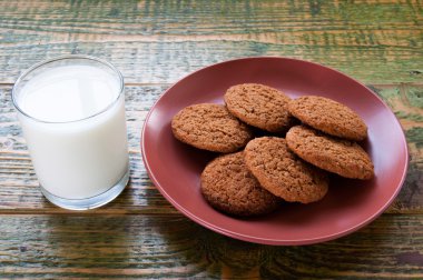 Süt cam kupa ile yulaf ezmeli kurabiye ahşap tablo.