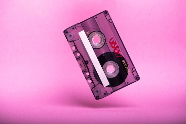 粉色背景的老式盒式磁带掉落 — 图库照片