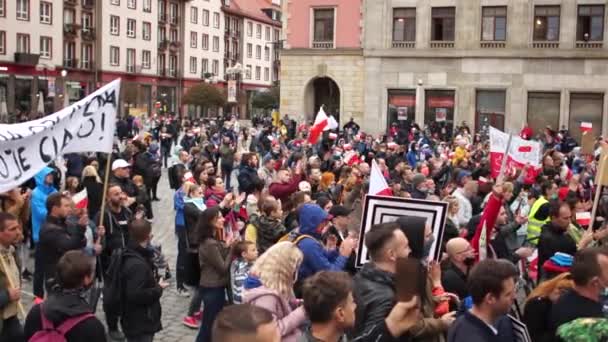 Wrocław, Polska - 10 października 2020 - Przeciwnicy ograniczeń COVID-19 przybyli na główny plac miasta z polskimi flagami. Napis po polsku - mój kraj moje ciało, wolni ludzie — Wideo stockowe