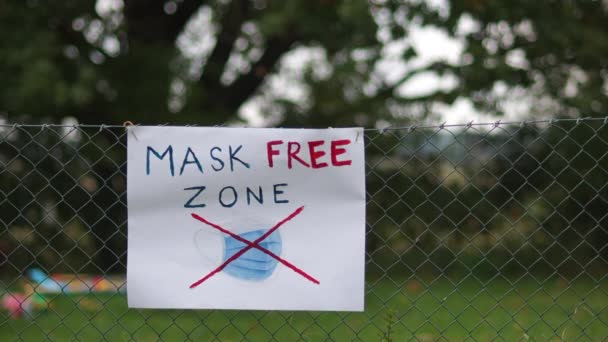La zona è libera da indossare maschere. Concetto anti-maschere, scettici codardi e la loro protesta. Il poster sulla recinzione — Video Stock