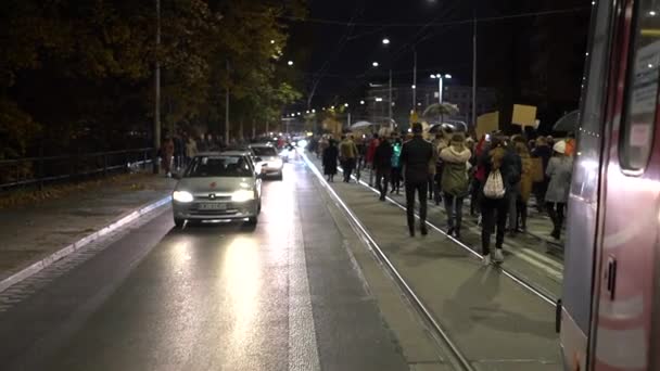 Wrocław, Polska, 26 października 2020 - polski strajk kobiet. Tłum z chorągwiami poruszający się wzdłuż drogi blokujący ruch miejskiego transportu. — Wideo stockowe