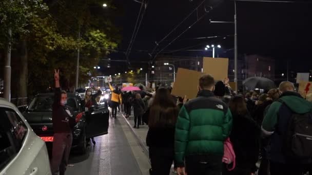 Wroclaw, Polen, 26 oktober 2020 Polske kvinders strejke. En menneskemængde med bannere bevæger sig langs vejen. Kvinder i biler blokerer bytrafikken. Polske bogstaver - revolutionens døtre, frit valg – Stock-video