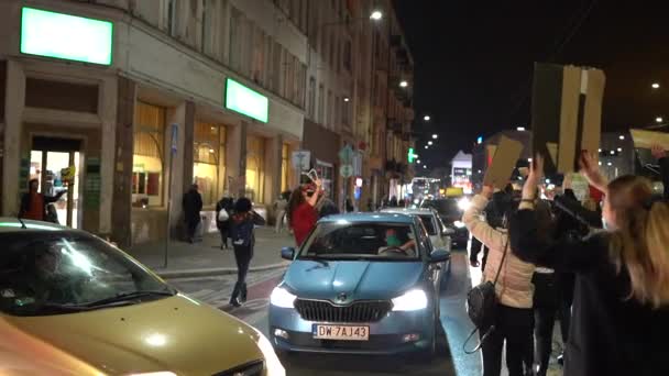 Wrocław, Polska, 26 października 2020 - polski strajk kobiet. Tłum z chorągwiami poruszający się wzdłuż drogi. Kobiety w samochodach blokują ruch w mieście. Dziewczyna w oknie samochodu trzyma wieszaki - symbol protestu — Wideo stockowe