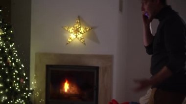 Aile sorunları konsepti, mali sorunlar ve Noel. Bir çift şöminenin yanında rahat bir evde oturuyor. Adam odada yürüyor ve gergin bir şekilde konuşuyor, kadın ona endişeyle bakıyor.