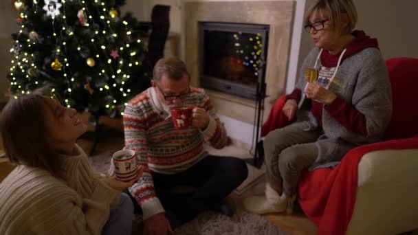 The family celebrates Christmas Eve by the fireplace and the Christmas tree. Christmas during the COVID-19 coronavirus lockdown — Stock Video