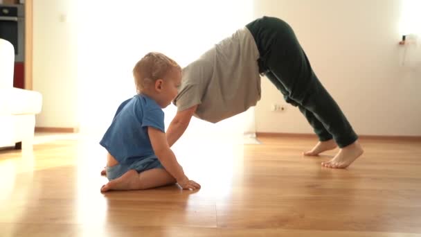 Mamma e figlio bambino facendo esercizi di yoga a casa sul pavimento durante la quarantena covid-19 coronavirus — Video Stock