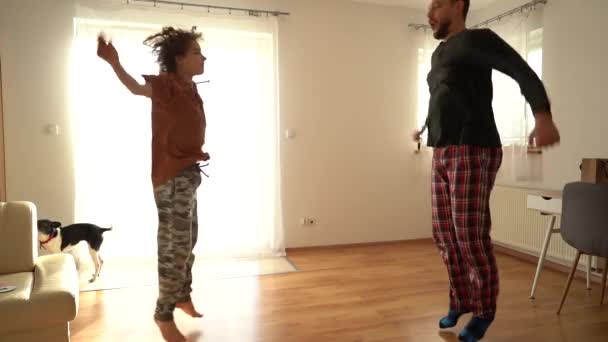 Rolig video far tränar sin son, pojke och far i pyjamas gör en rolig uppvärmning innan gymnastik. Fäder dag, stanna hemma — Stockvideo
