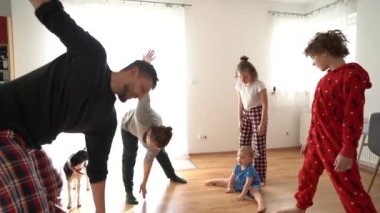 Karı koca ve üç çocuk, mutlu aile, komik video. Sabahları pijamalarıyla egzersiz yapan üç çocuklu büyük bir aile. Eğlenceli kilitleme, evde kal