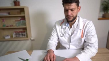 Aile doktoru, terapist bir hastaya çevrimiçi danışmanlık yapıyor ve bilgisayarla veri kaydediyor. Salgın sırasında ilaç, teletıp konsepti