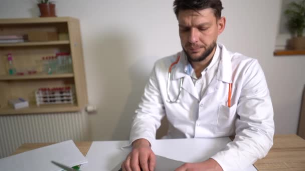 Medico di famiglia, terapeuta consulta un paziente online e registra i dati utilizzando un computer portatile. Medicina durante una pandemia, concetto di telemedicina — Video Stock