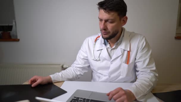 Experienced therapist carefully examines the X-ray picture of the patient. Making a diagnosis during the covid-19 coronavirus pandemic — Stock Video